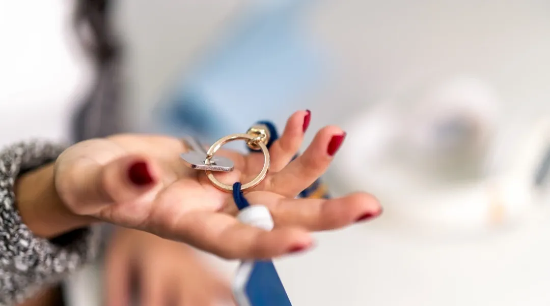 Hand mit Wohnungsschlüssel als Übergabe bei Mietvertrag