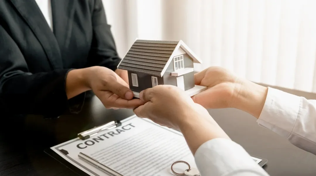 Symbolische Hausübergabe über Mietvertrag mit Vertragstext