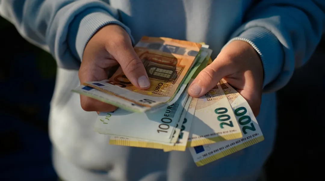 Person zählt Euro-Geldscheine für Mietkaution