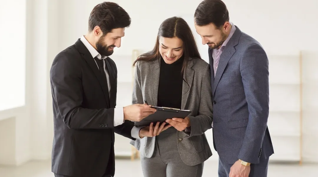 Drei Personen prüfen Mietunterlagen und besprechen Rückzahlung des Mietzinsdepots